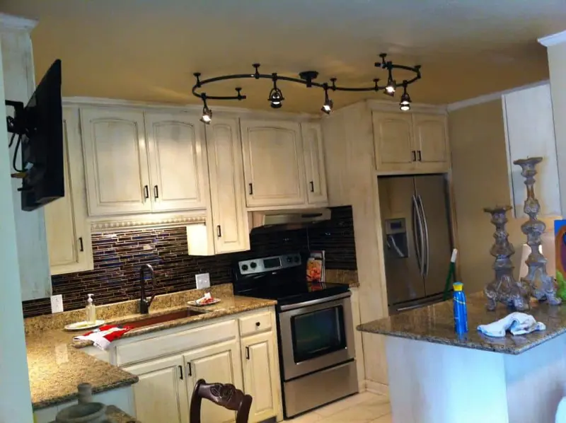 Remodeled kitchen with white cabinets and stainless appliances