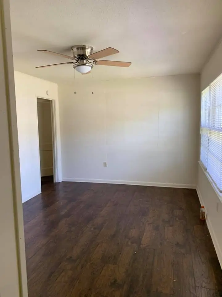 Freshly painted empty room with new flooring, ready for the next tenant
